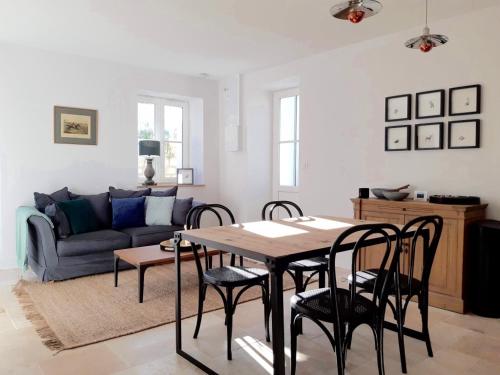 a living room with a table and chairs and a couch at L'ancien Presbytère in Coye-la-Forêt