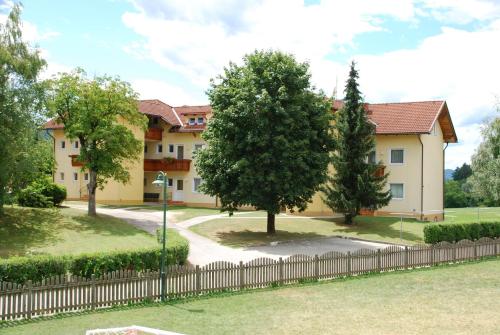 un edificio con una valla delante de un patio en Haus Sonnhügel, en Sankt Kanzian
