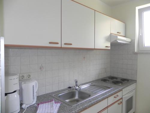a kitchen with a sink and a counter top at Apartments Kleinseeblick in Sankt Kanzian