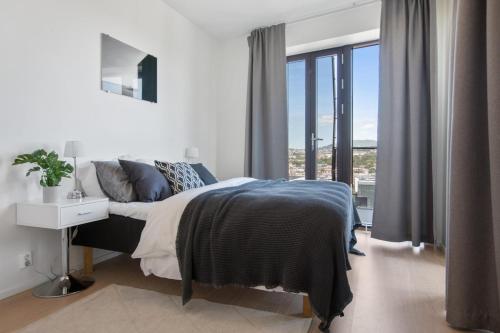 a bedroom with a large bed and a large window at BJØRVIKA APARTMENTS, Opera Area, Oslo city center in Oslo