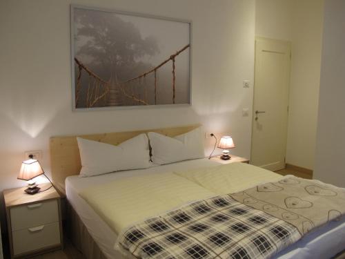 een slaapkamer met een bed met een brugwerf aan de muur bij Appartamenti Col Rodella in Campitello di Fassa