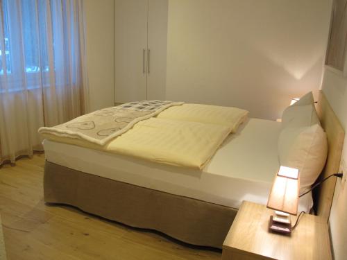 a bedroom with a bed and a lamp on a table at Appartamenti Col Rodella by AMA Val di Fassa in Campitello di Fassa