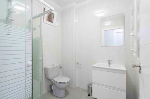 Baño blanco con aseo y lavamanos en The Rentals Collection | Coeur, en San Sebastián
