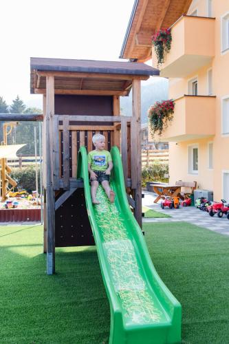 a child on a slide at a playground at Knappensteig Appartements in Wagrain