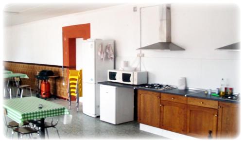 a kitchen with a refrigerator and a table and chairs at La Masia in Sant Pere Pescador