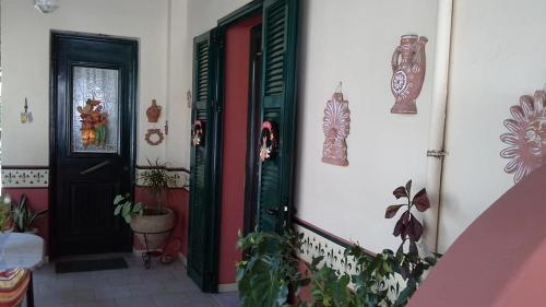 an entrance to a house with green doors and plants at Villa Manolis in Tolo