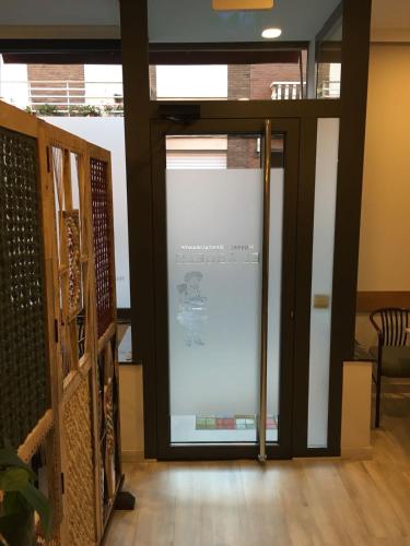 a glass door with a sign on it in a room at Hostal Restaurante El Abuelo in Trobajo del Camino