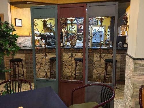 a room with a bar with stained glass doors at Hostal Restaurante El Abuelo in Trobajo del Camino