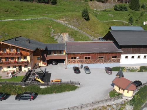an aerial view of a building with cars parked in a parking lot at Appartmenthof Aigengut Ferienwohnung Großarl in Grossarl