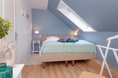 a bedroom with a bed with a blue wall at Weisse Düne - Ost in Wenningstedt