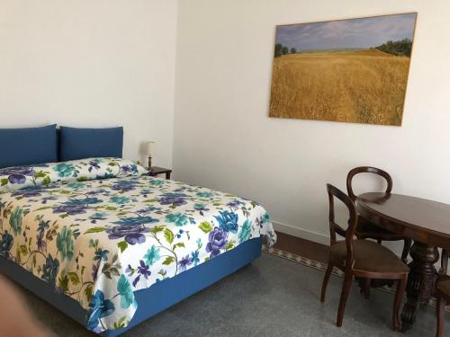 een slaapkamer met een bed, een bureau en een tafel bij All'Angolo B&B in Matera