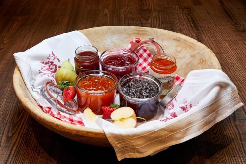 a wooden bowl filled with jam and jams and fruit at Hotel Neue Post in Mayrhofen