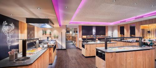 a large kitchen with wooden counter tops and purple lighting at Hotel Neue Post in Mayrhofen