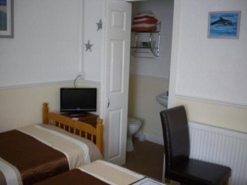 a room with a bedroom with a bed and a television at Sheridan in Scarborough