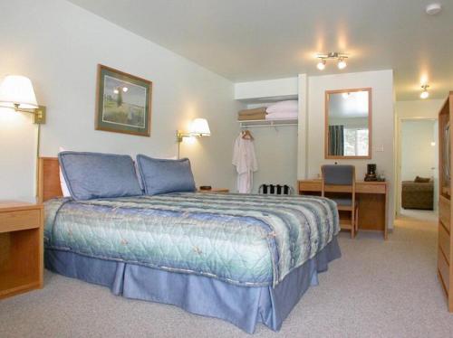 a hotel room with a bed and a bathroom at New Horizon Motel in Christina Lake