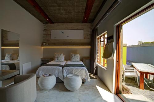 1 dormitorio con cama y ventana grande en Organic Stay Guesthouse, en Swakopmund