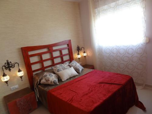 1 dormitorio con cama roja y ventana en Infostays María Zambrano - Free Parking en Málaga