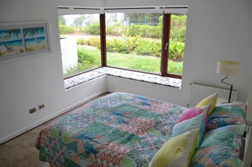 a bedroom with a bed and a large window at Departamento Maitencillo Costamai in Maitencillo