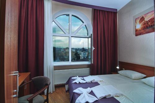 um quarto de hotel com uma cama e uma janela em Kolizey Hotel em Kislovodsk
