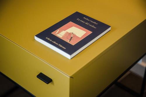 a book sitting on top of a yellow table at Plebis - B&B in Sicilia nel centro storico di Catania in Catania