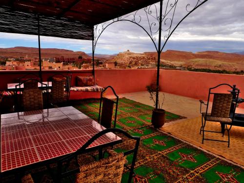 a patio with chairs and a view of the desert at Maison d'Hôtes Nouflla in Aït Benhaddou