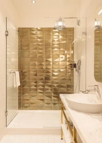 a bathroom with a tub and a sink and a shower at Hotel Schani Salon in Vienna