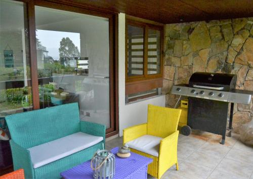 a patio with two chairs and a grill and a table at Departamento Maitencillo Costamai in Maitencillo