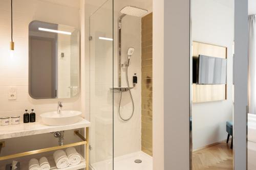 a bathroom with a shower, sink, and toilet at Hotel Schani Salon in Vienna