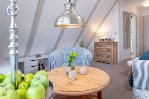a living room with a table and chairs and a table and a table at Weisse Düne - West in Wenningstedt