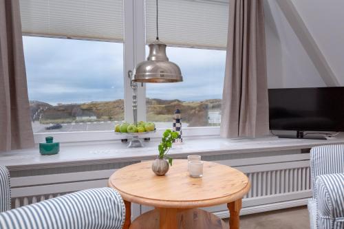 a living room with a table and a window at Weisse Düne - West in Wenningstedt