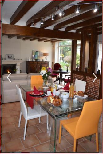 une salle à manger avec une table sur laquelle se trouve de la nourriture dans l'établissement A La Chataigneraie, à Mosnes