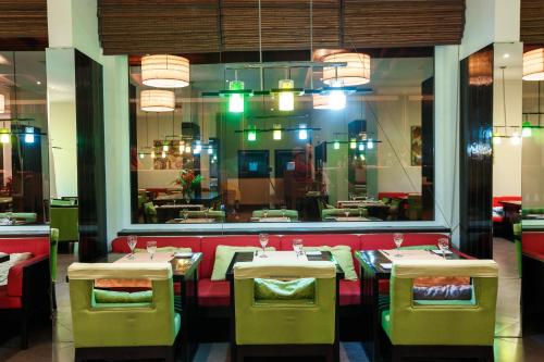 a dining room with tables and chairs and a window at Calypso Hôtel in Toamasina
