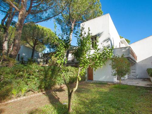 ein weißes Haus mit einem Baum im Hof in der Unterkunft Holiday Home Casa Polipo by Interhome in Principina a Mare