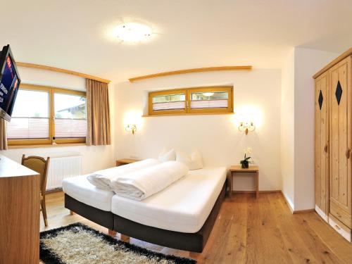 a bedroom with a large white bed in a room at Landhaus Anja in Neustift im Stubaital