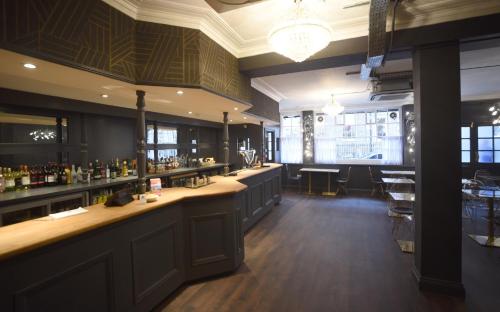 a bar in a restaurant with a long counter at The Pack And Carriage London in London