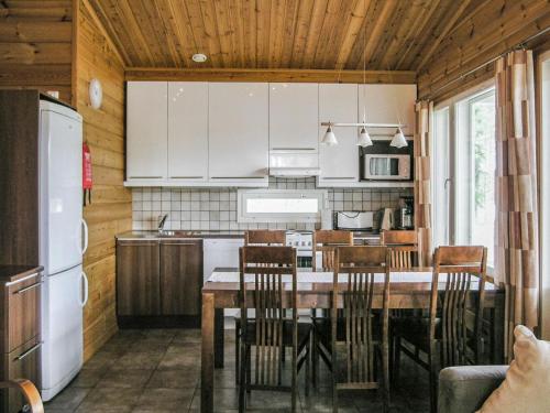 a kitchen with a table and chairs and a refrigerator at Holiday Home Yläneuvola lanssi by Interhome in Neuvola