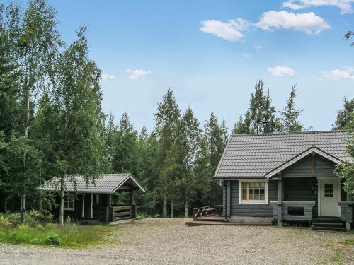 a cabin and a house with a gravel driveway at Holiday Home Juvan-vuokko by Interhome in Lahdenperä
