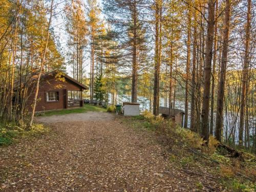 a dirt road leading to a cabin in the woods at Holiday Home Aurinkorinne by Interhome in Vuoriniemi