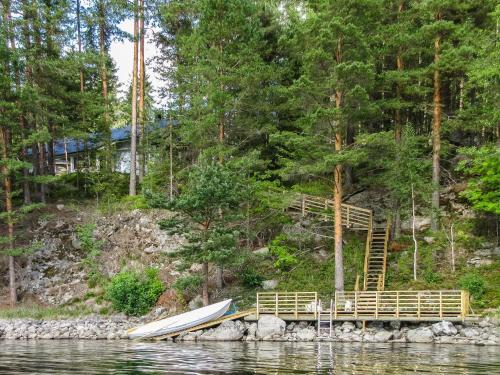 a wooden dock with a boat on the water at Holiday Home Kuutti by Interhome in Vuoriniemi