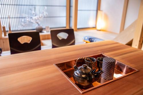 a wooden table with a tea pot on top of it at Inari Ohan in Kyoto