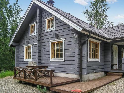 a black house with a picnic table in front of it at Holiday Home Juvan-vuokko by Interhome in Lahdenperä