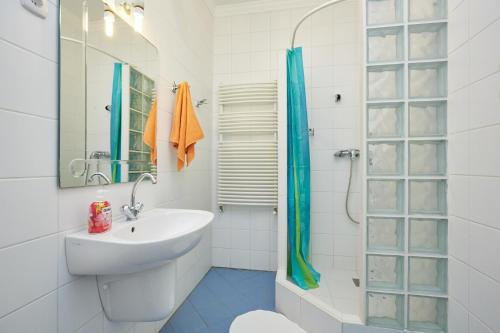 a white bathroom with a sink and a shower at Zoli Apartmanok-Anna Kölcsey 32 in Hajdúszoboszló
