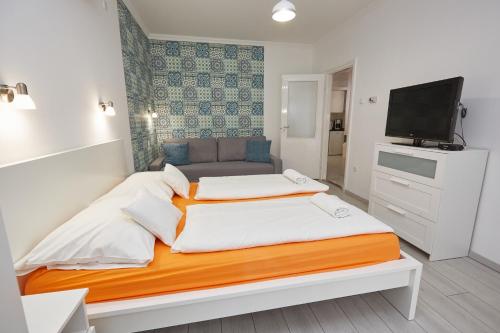 a bedroom with a large bed and a television at Zoli Apartmanok-Anna Kölcsey 32 in Hajdúszoboszló