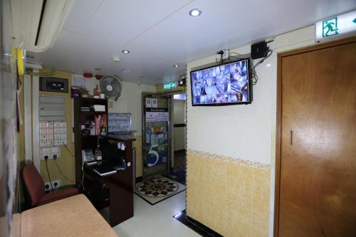 um quarto com uma televisão na parede de uma loja em Everest Hostel 14/F em Hong Kong
