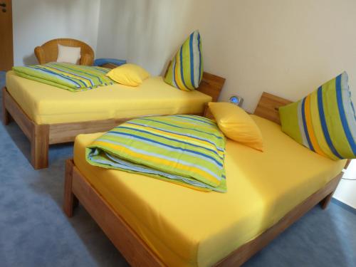 2 camas en una habitación con sábanas y almohadas amarillas en Ferienwohnung am Weyer, en Solingen