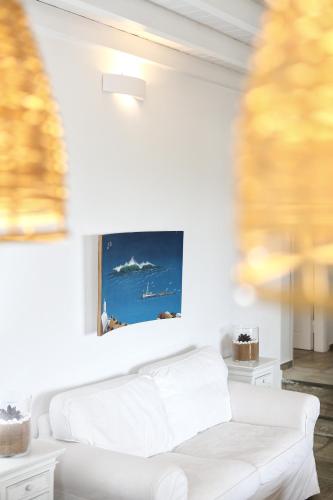 a white couch in a living room with a painting on the wall at VLIA MAR Myconian Residences in Kalafatis