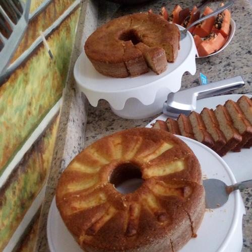 un tavolo ricoperto di torte e prodotti da forno su piatti di Pousada Serenna Centro a Tiradentes