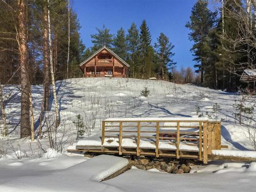 a wooden bridge in the snow in front of a cabin at Holiday Home Etelärinne by Interhome in Vuoriniemi