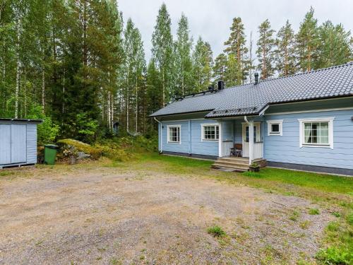 a blue house in the middle of a yard at Holiday Home Kuutti by Interhome in Vuoriniemi