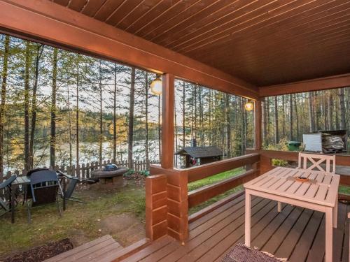 a screened in porch of a cabin with a picnic table at Holiday Home Aurinkorinne by Interhome in Vuoriniemi